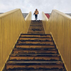 Image d'illustration d'une femme qui gravit les marches d'un escalier